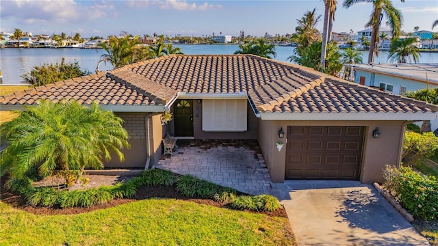 mediterranean / spanish home with a water view and a garage