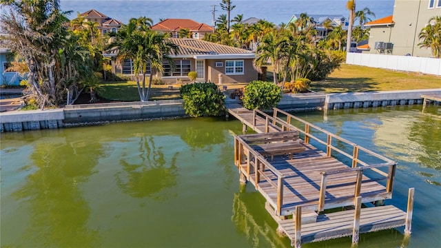 view of dock with a water view and a yard