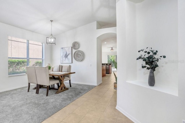 dining room featuring light tile patterned floors and ceiling fan with notable chandelier