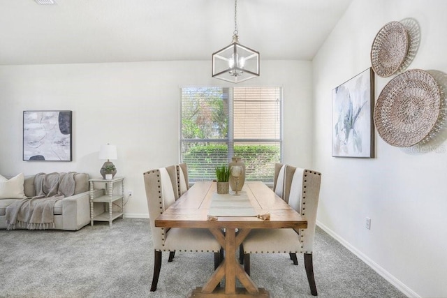 dining area with carpet flooring and a chandelier