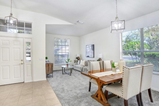 dining space with light tile patterned floors and an inviting chandelier