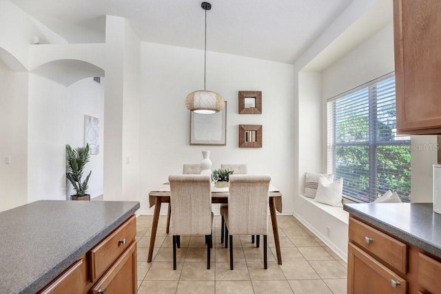 tiled dining space with lofted ceiling