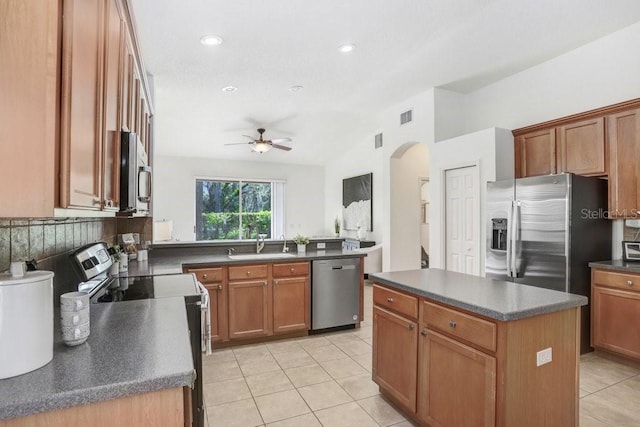 kitchen with ceiling fan, a center island, sink, stainless steel appliances, and light tile patterned floors