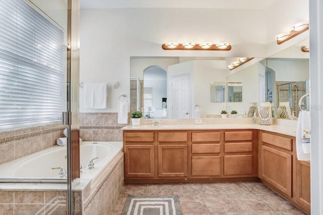 bathroom featuring vanity and independent shower and bath