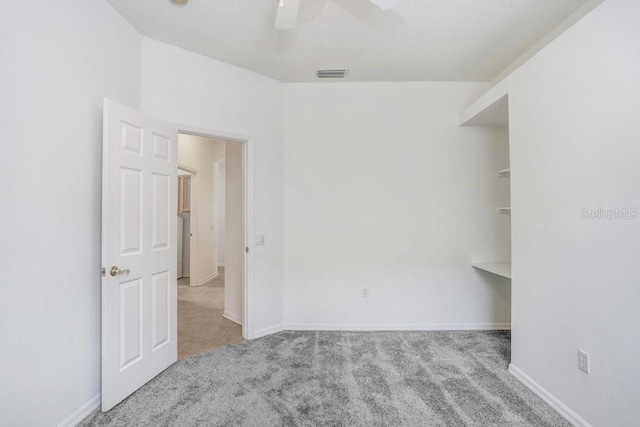 carpeted spare room with ceiling fan