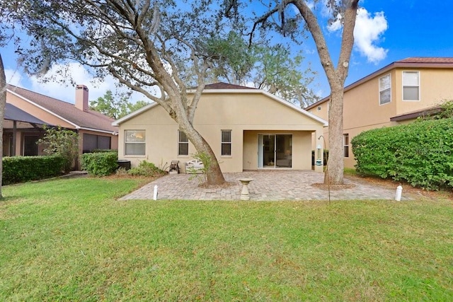 back of house with a lawn and a patio