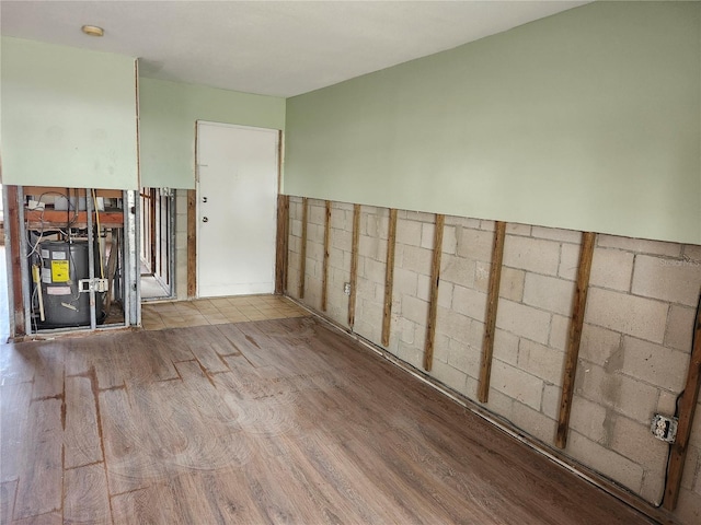 empty room featuring electric water heater and light hardwood / wood-style flooring