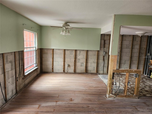 empty room with hardwood / wood-style floors, a textured ceiling, and ceiling fan