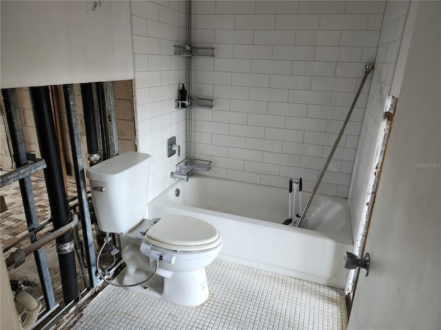 bathroom with tile patterned flooring, tiled shower / bath combo, and toilet