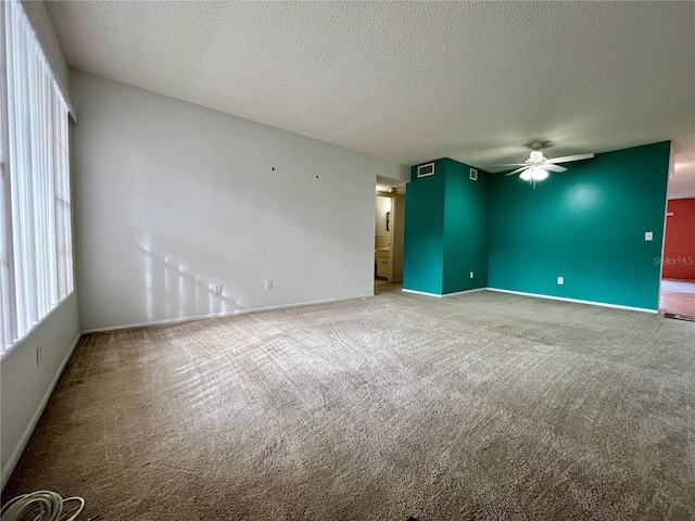 carpeted spare room with a textured ceiling and ceiling fan