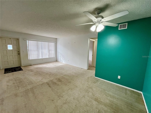 unfurnished living room with light carpet, a textured ceiling, and ceiling fan