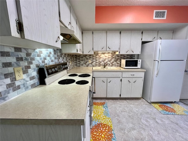 kitchen featuring decorative backsplash, sink, and white appliances