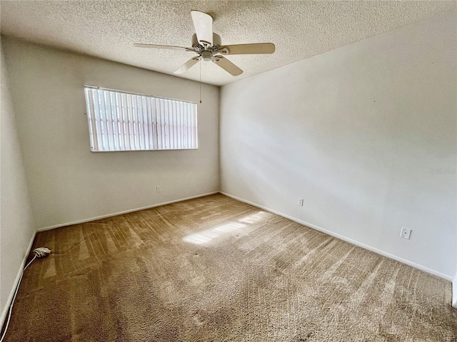 empty room featuring ceiling fan, carpet, and a textured ceiling