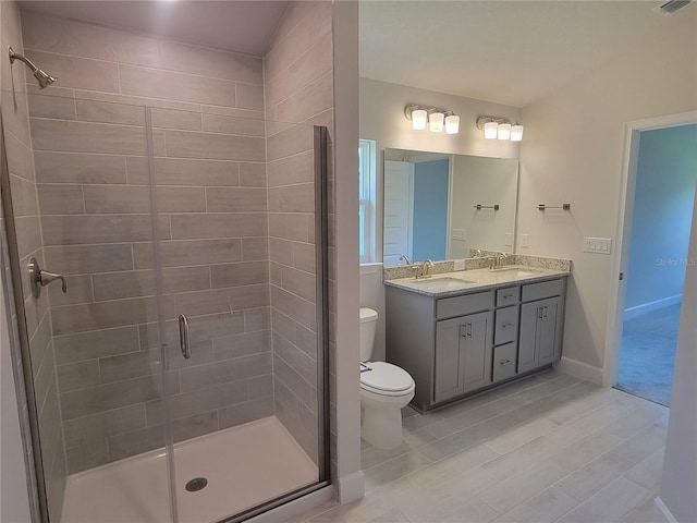 bathroom with tile patterned floors, toilet, vanity, and walk in shower