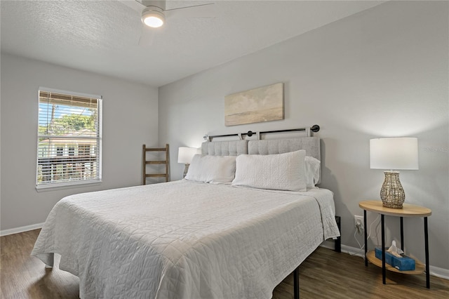 bedroom featuring a textured ceiling, ceiling fan, and dark hardwood / wood-style flooring