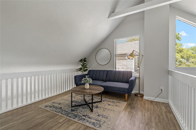 living area with vaulted ceiling with beams and hardwood / wood-style floors