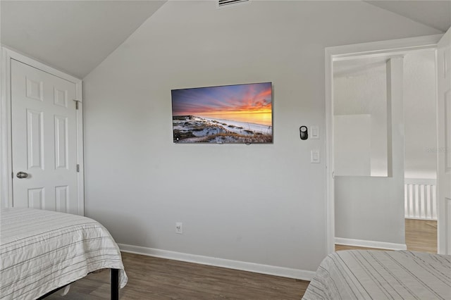 bedroom featuring dark wood-type flooring and lofted ceiling