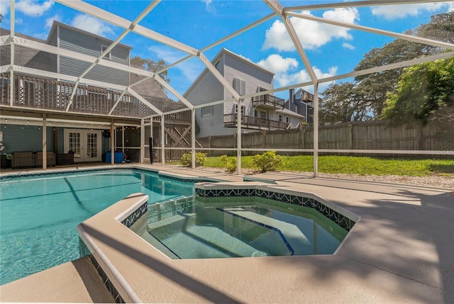 view of swimming pool with an in ground hot tub, a patio area, glass enclosure, and french doors