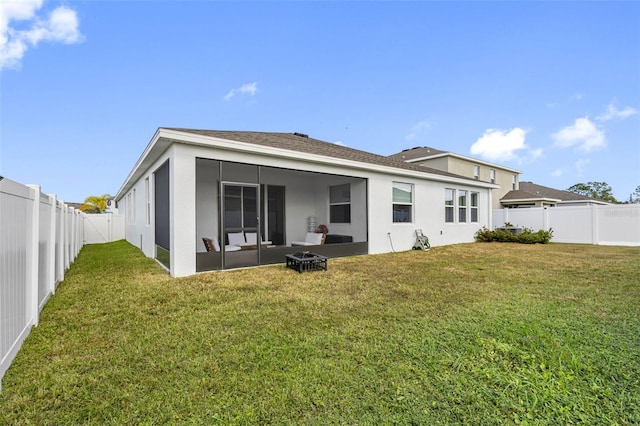 rear view of house with a lawn and a sunroom