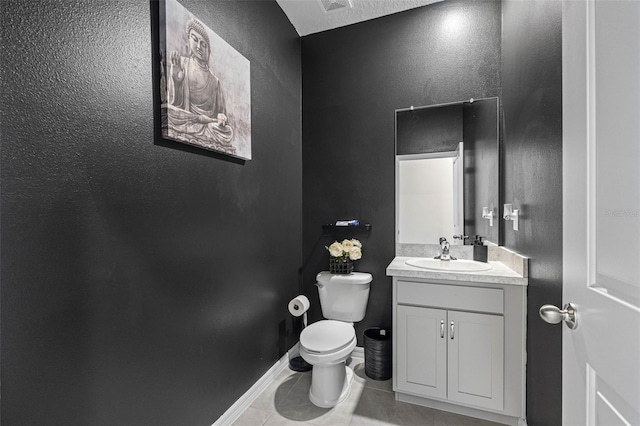 bathroom with tile patterned flooring, vanity, and toilet