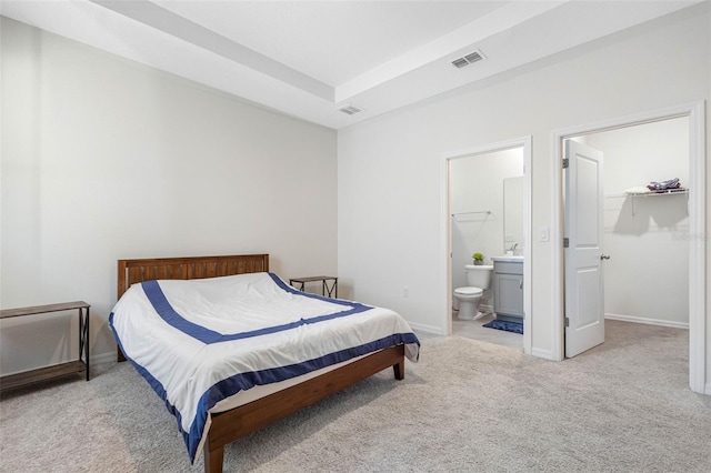 carpeted bedroom with a spacious closet, connected bathroom, and a closet