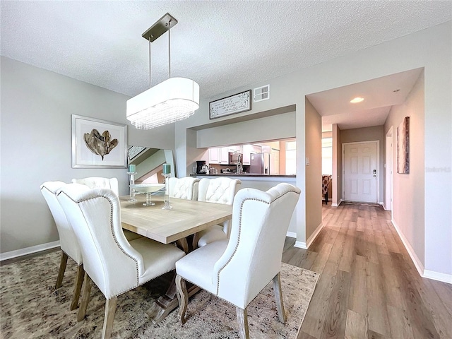 dining area featuring hardwood / wood-style floors and a textured ceiling