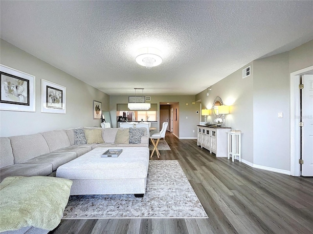 living room with dark hardwood / wood-style flooring and a textured ceiling