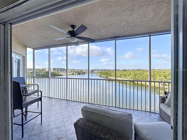 sunroom featuring a wealth of natural light, a water view, and ceiling fan