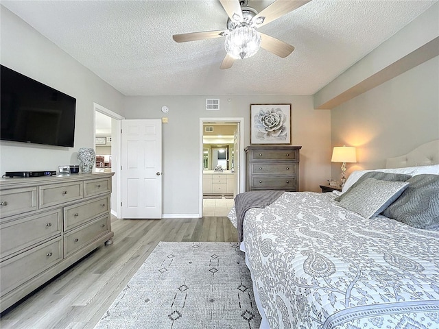 bedroom featuring connected bathroom, ceiling fan, light hardwood / wood-style flooring, and a textured ceiling