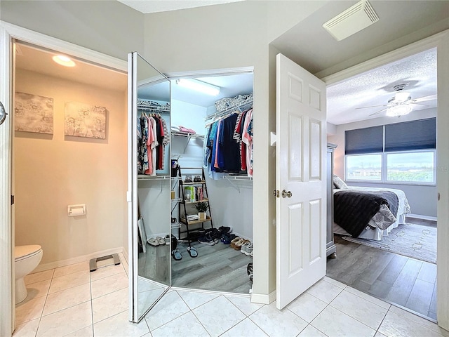 bathroom featuring toilet, a textured ceiling, tile patterned floors, and ceiling fan