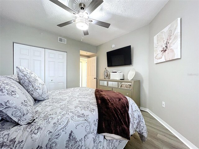 bedroom featuring hardwood / wood-style floors, ceiling fan, a textured ceiling, and a closet