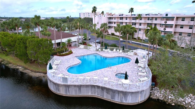 view of pool with a water view and a patio