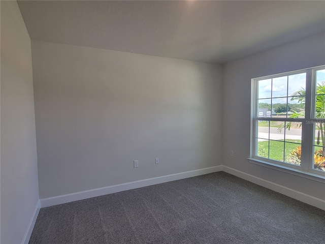 spare room featuring dark colored carpet