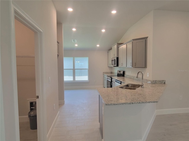 kitchen with sink, stainless steel appliances, light stone counters, kitchen peninsula, and gray cabinets