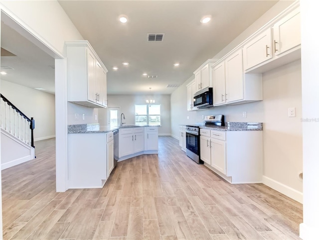 kitchen with light hardwood / wood-style flooring, appliances with stainless steel finishes, light stone counters, white cabinets, and kitchen peninsula