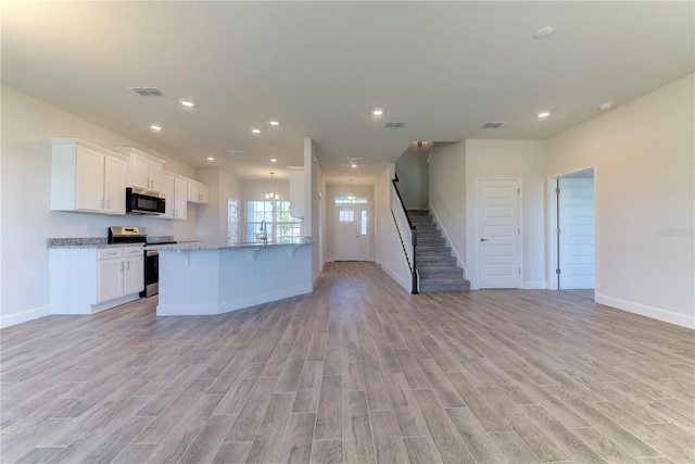 kitchen with electric stove, white cabinets, kitchen peninsula, light stone countertops, and light hardwood / wood-style flooring