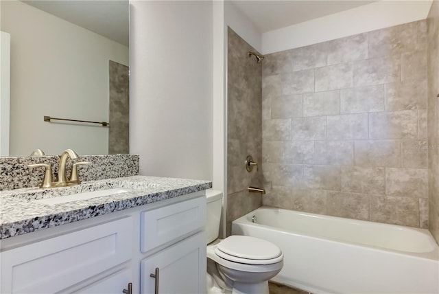 full bathroom featuring tiled shower / bath, vanity, and toilet