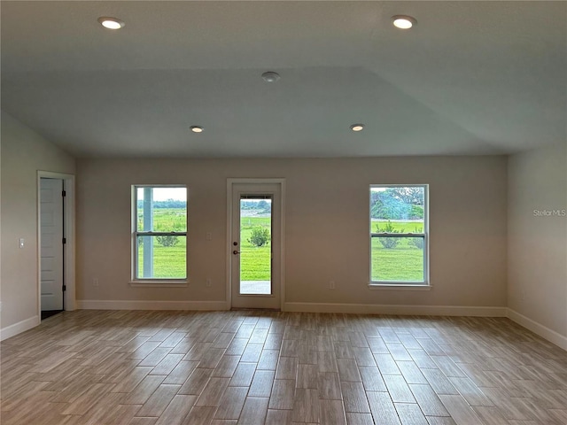 unfurnished room with vaulted ceiling