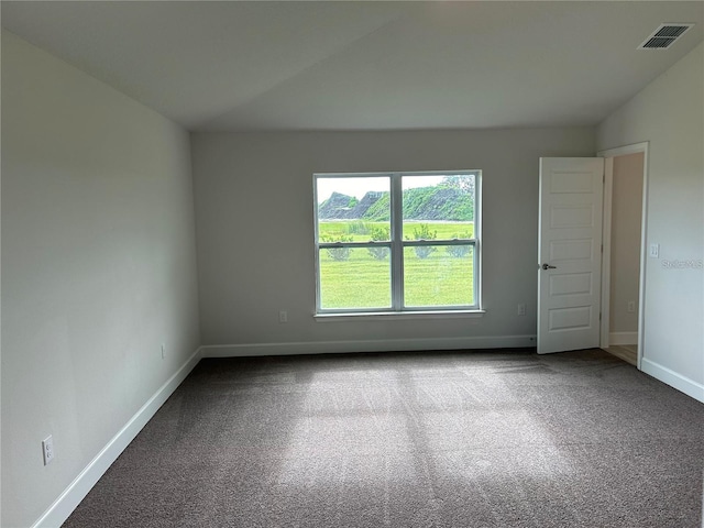 carpeted empty room featuring lofted ceiling