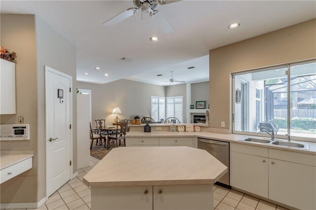 kitchen with dishwasher, a kitchen island, sink, and ceiling fan