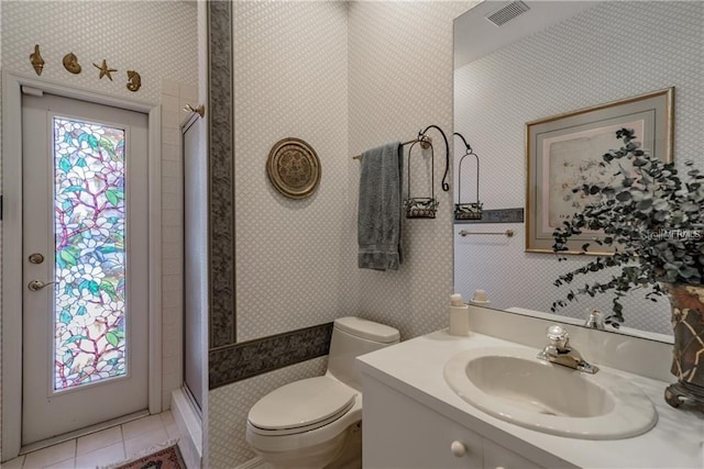 bathroom with tile patterned flooring, vanity, toilet, and a shower with door