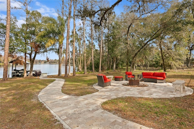 view of yard featuring a water view, a fire pit, and a patio area