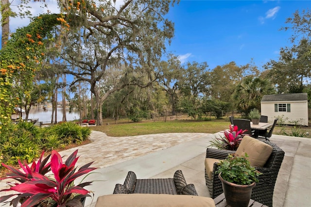 view of patio with a water view and a storage shed