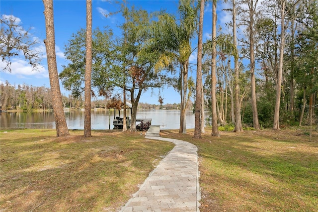 exterior space featuring a dock, a water view, and a front yard