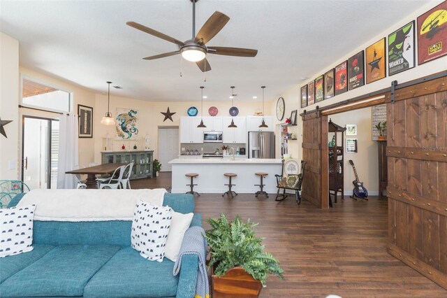 10328 Henderson St, Spring Hill, FL 34608 - living room featuring a barn door, ceiling fan, and dark hardwood / wood-style floors