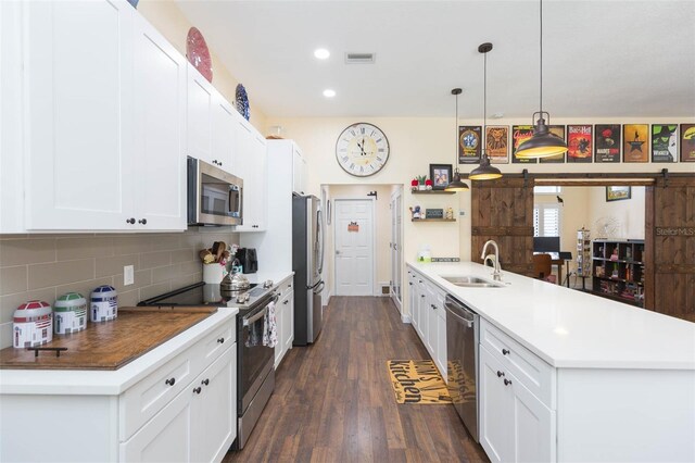 10328 Henderson St, Spring Hill, FL 34608 - kitchen with decorative backsplash, appliances with stainless steel finishes, a barn door, and white cabinets