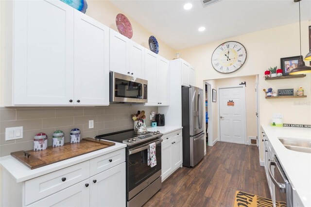 10328 Henderson St, Spring Hill, FL 34608 - kitchen with white cabinetry, tasteful backsplash, dark hardwood / wood-style flooring, decorative light fixtures, and appliances with stainless steel finishes