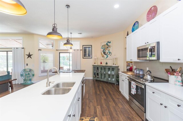 10328 Henderson St, Spring Hill, FL 34608 - kitchen with decorative backsplash, stainless steel appliances, white cabinets, and sink