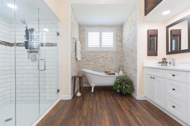 10328 Henderson St, Spring Hill, FL 34608 - bathroom featuring separate shower and tub, vanity, and wood-type flooring