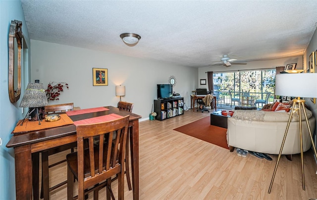 living room with hardwood / wood-style floors, ceiling fan, and a textured ceiling